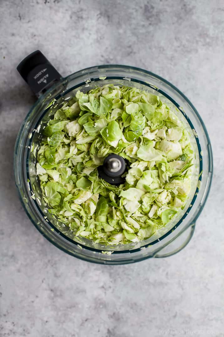 Top view of chopped brussels sprouts in a food processor bowl