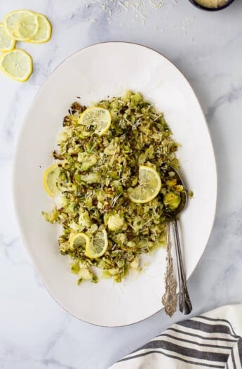 Garlic Parmesan Roasted Brussels Sprouts make a quick easy side dish the family will love. These Brussels Sprouts are tossed with shredded parmesan, loads of garlic and fresh lemon juice for one delicious gluten free recipe!