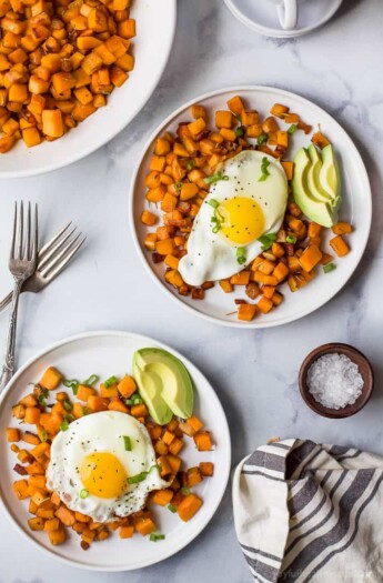 Two plates of sweet potatoes with eggs and creamy avocado.