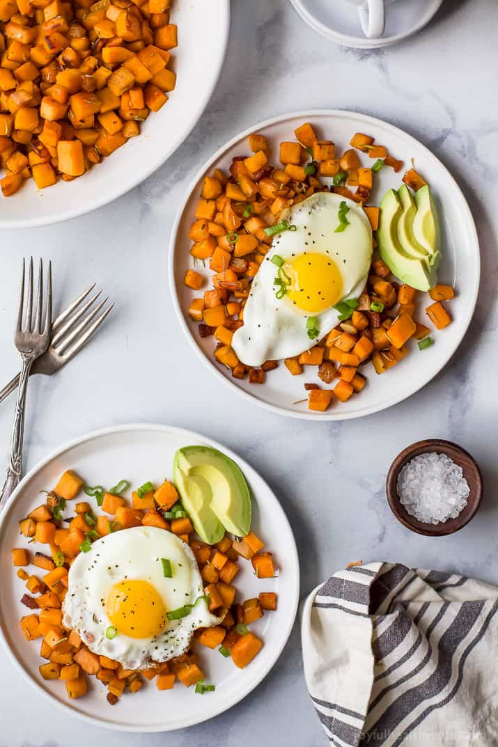 This home -made sweet potato hash recipe, including crispy bacon, smoky paparika, herbal and eggs, is a simple breakfast. Two plates of sweet potato with eggs and creamy avocado.