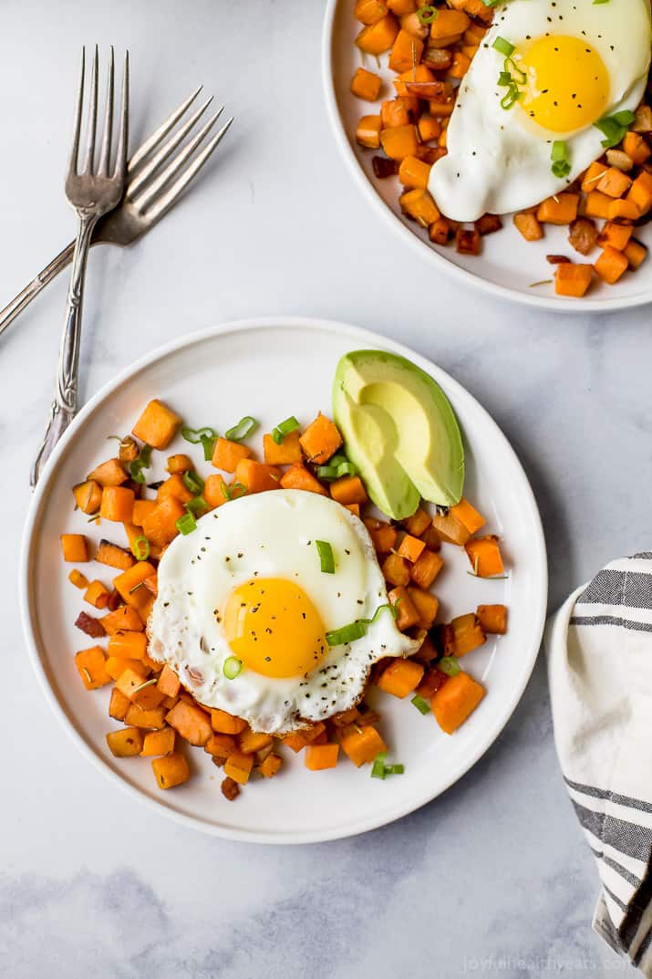 paleo sweet potato hash & eggs on a plate with an avocado