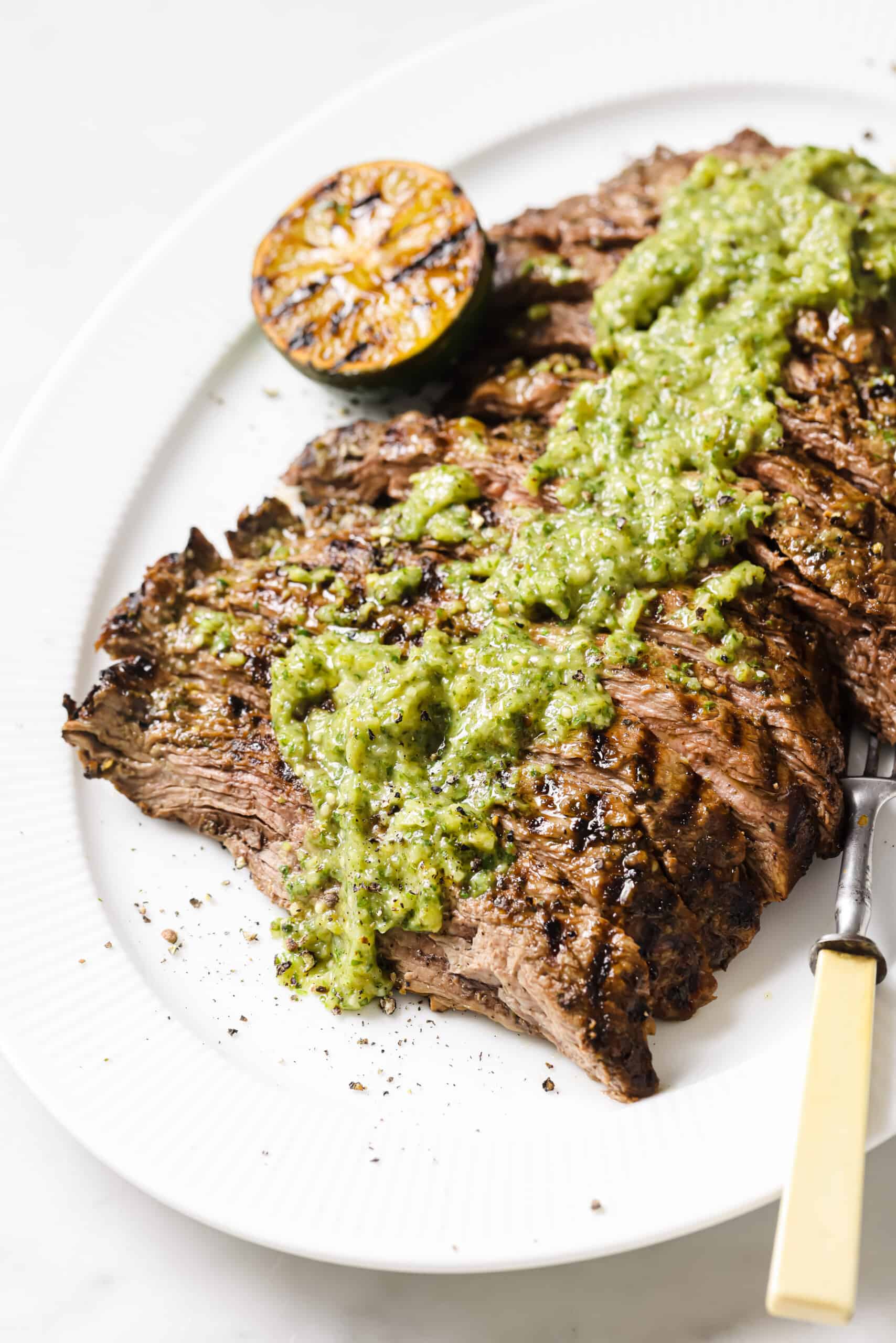 This easy carne asada recipe with salsa verde will be your new favorite Mexican dinner. Easy to make and super juicy, it's the perfect dish! Carne asada recipe on a serving plate.