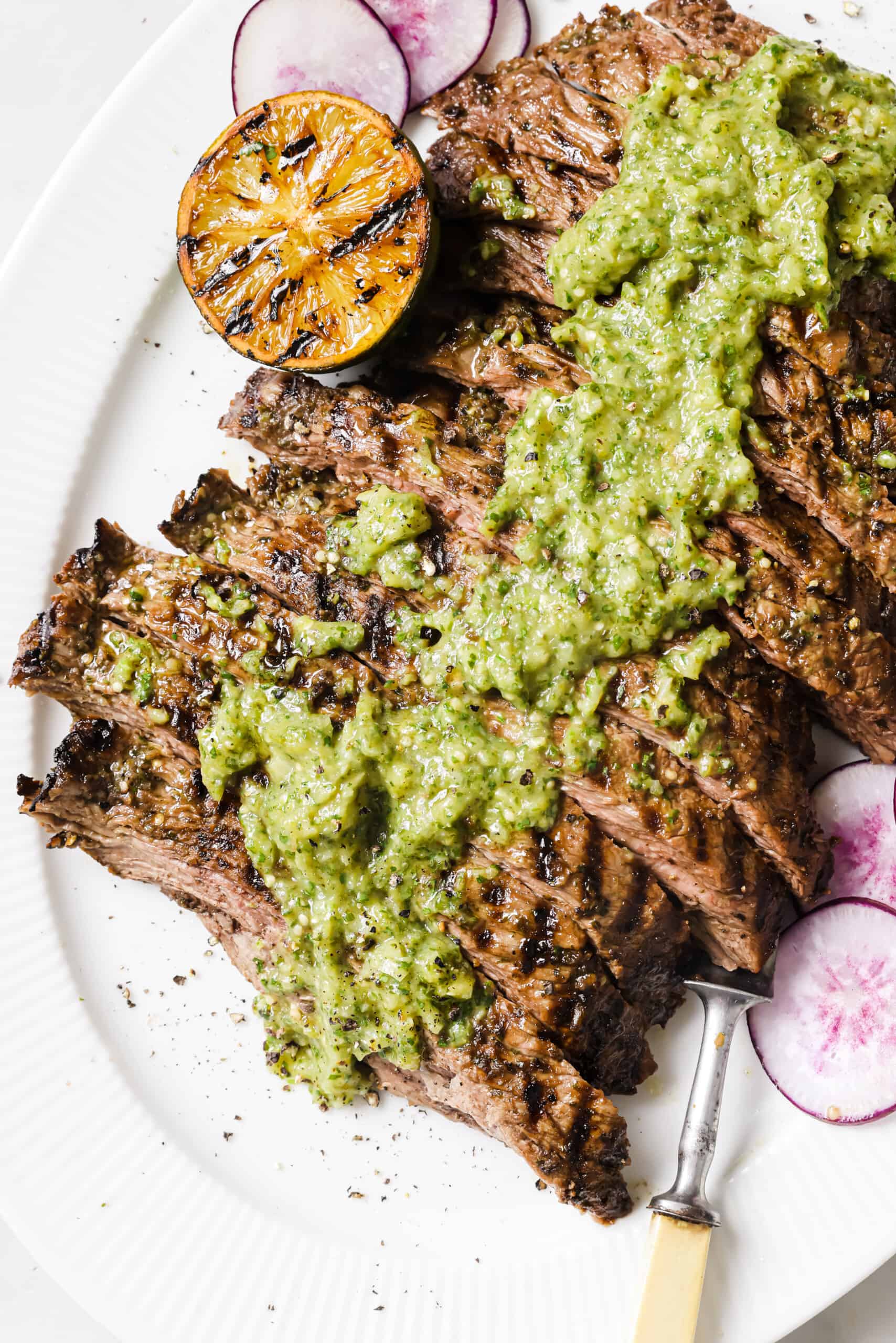 Sliced carne asada recipe with salsa on top. 