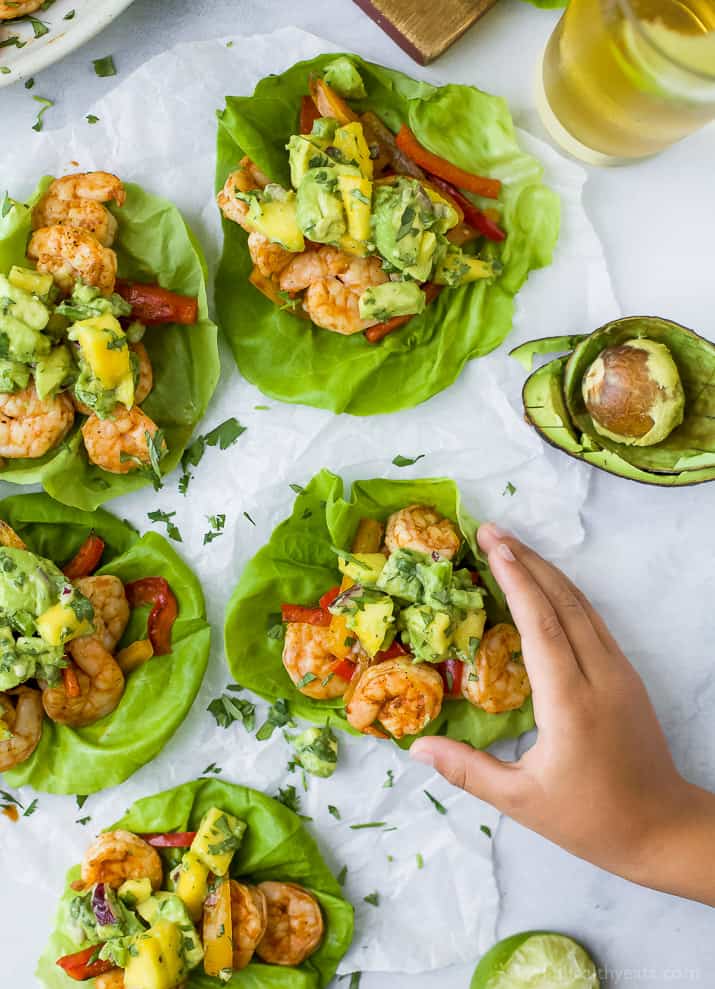 Easy 30 minute Grilled Shrimp Tacos topped with a fresh Mango Avocado Salsa. These flavor bursting gluten free tacos make the perfect light healthy dinner your family will love!