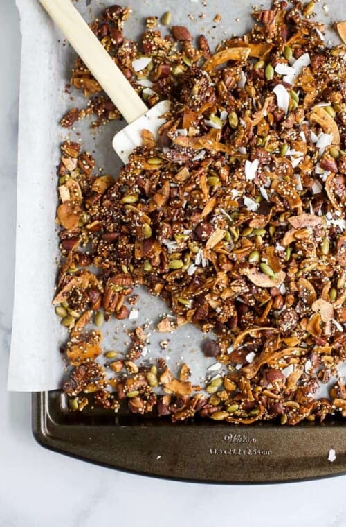 Rubber spatula on sheet pan with gluten free granola.