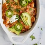 Gluten Free Sweet Potato Black Bean Enchiladas covered in a smoky red chili sauce and gooey cheese. Simple ingredients and lots of flavor make these black bean enchiladas a must try dinner recipe!