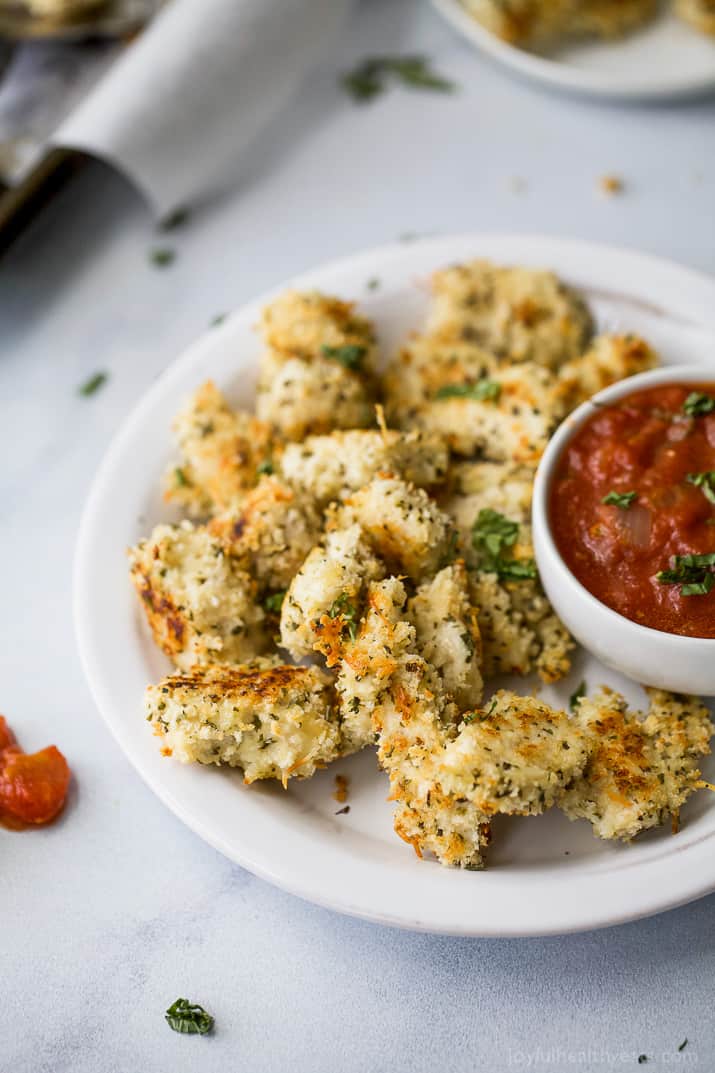 Baked Chicken Parmesan Bites with a cup of homemade marinara sauce on a plate