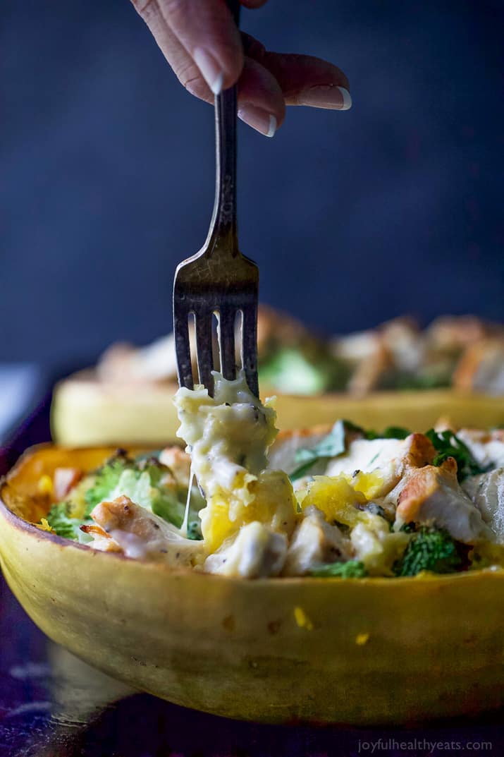 A fork spearing a bite of Chicken Alfredo Stuffed Spaghetti Squash