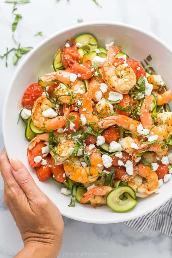 Bowl of creamy zoodle shrimp pasta with goat cheese and blistered tomatoes.