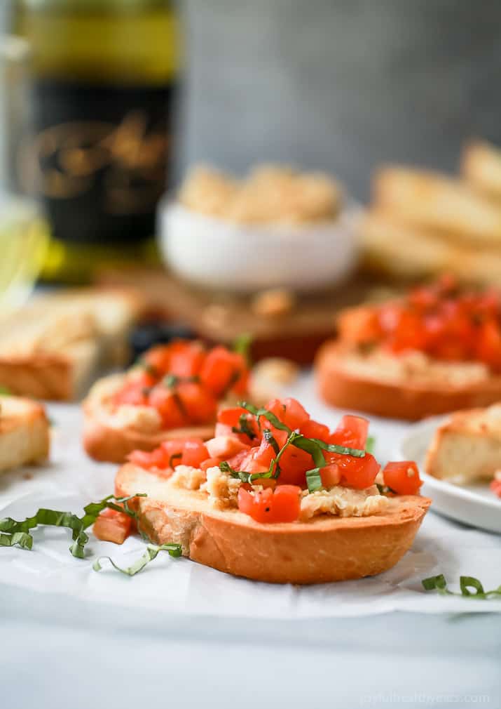 Smashed Chickpea Crostini topped with a fresh tomato Bruschetta - a light vegetarian appetizer perfect for the summer!