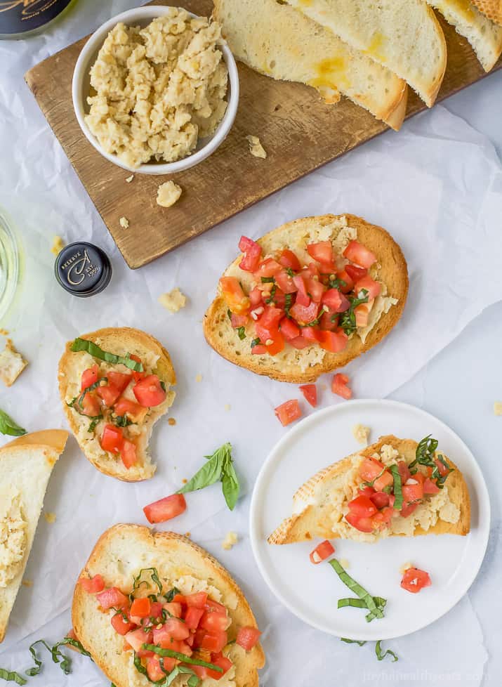 Smashed Chickpea Crostini topped with a fresh tomato Bruschetta - a light vegetarian appetizer perfect for the summer!