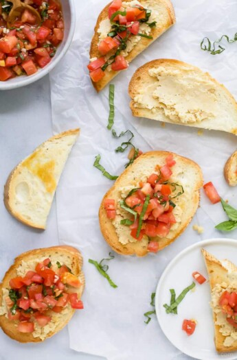 Some pieces of Smashed Chickpea Bruschetta Crostini on a table.