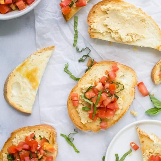 Some pieces of Smashed Chickpea Bruschetta Crostini on a table.