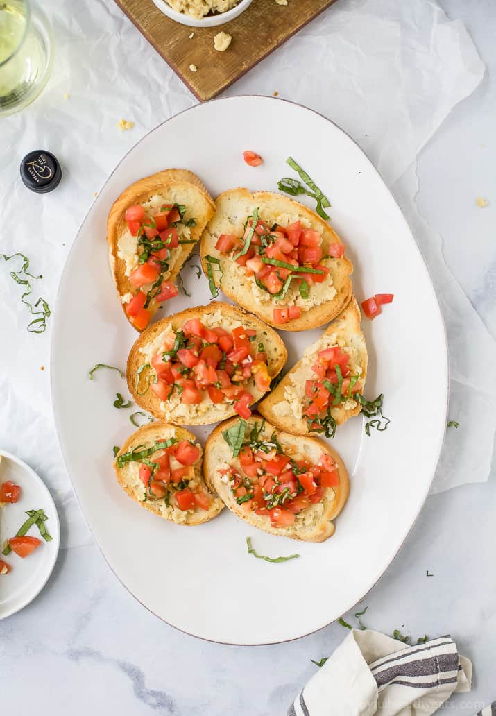 Smashed Chickpea Crostini topped with a fresh tomato Bruschetta - a light vegetarian appetizer perfect for the summer!