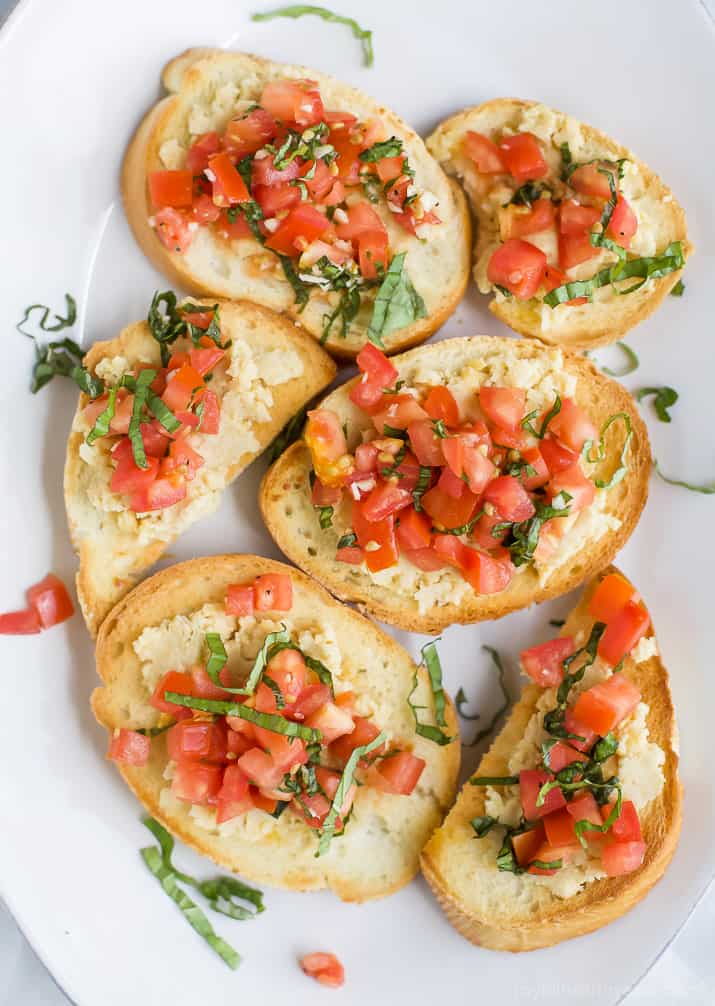 Smashed Chickpea Crostini topped with a fresh tomato Bruschetta - a light vegetarian appetizer perfect for the summer!