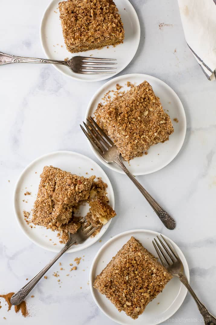 Slices of spiced apple coffee cake on 4 serving plates.