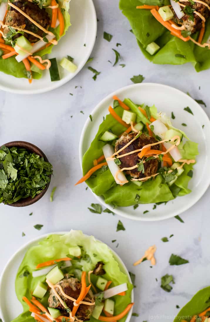 Top view of Banh Mi Lettuce Wraps on plates with turkey meatballs served on a lettuce wrap with pickled vegetables and sriracha mayo