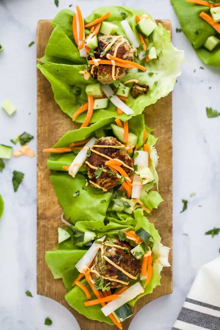 Top view of three Banh Mi Lettuce Wraps with turkey meatballs served on a lettuce wrap with pickled vegetables and sriracha mayo