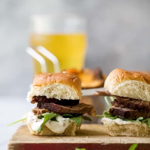 Beer Braised Slow Cooker Brisket Sliders tender moist brisket served on Hawaiian rolls then slathered with a creamy horseradish aioli. This easy flavorful appetizer is sure to be devoured as soon as it hits the table!