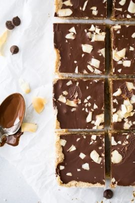 healthy no bake almond joy bars with a spoon of chocolate next to them