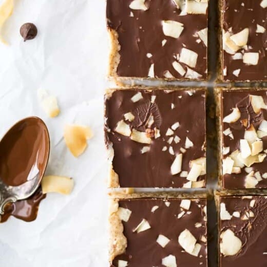 healthy no bake almond joy bars with a spoon of chocolate next to them