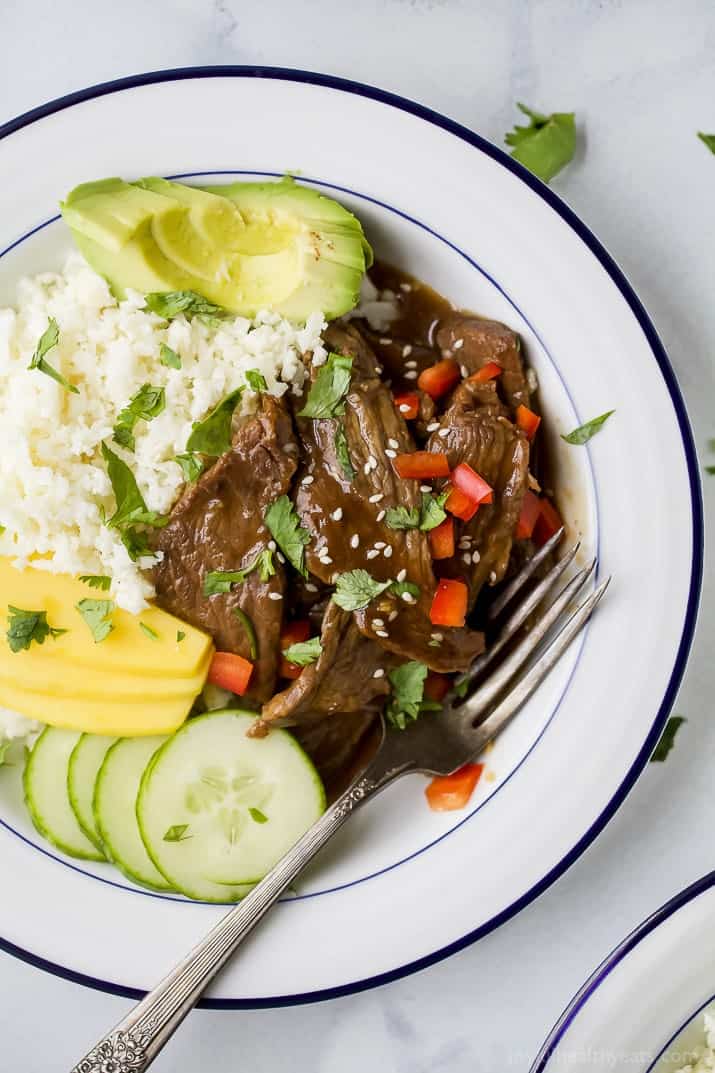 Top view of Instant Pot Korean Beef Bowl on a bed of cauliflower rice with mango and avocado