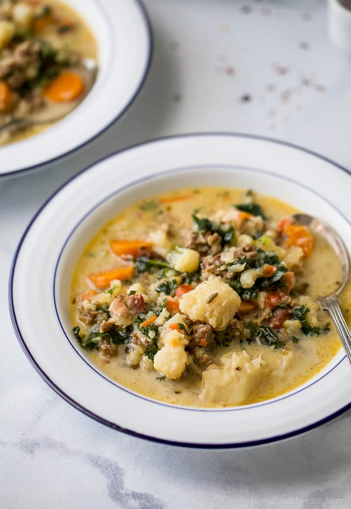 This copycat zuppa toscana recipe is loaded with sausage, bacon, and fresh veggies for a comforting Instant Pot dinner. Homemade zuppa toscana with sausage, bacon, and veggies in a bowl.