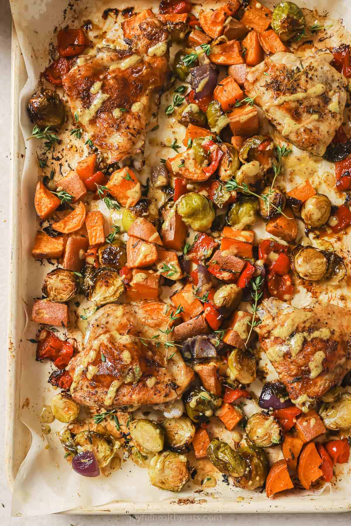 Broiled chicken and veggies on the baking sheet. 