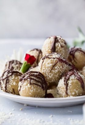 gluten free almond snowball cookies with chocolate drizzle on a plate