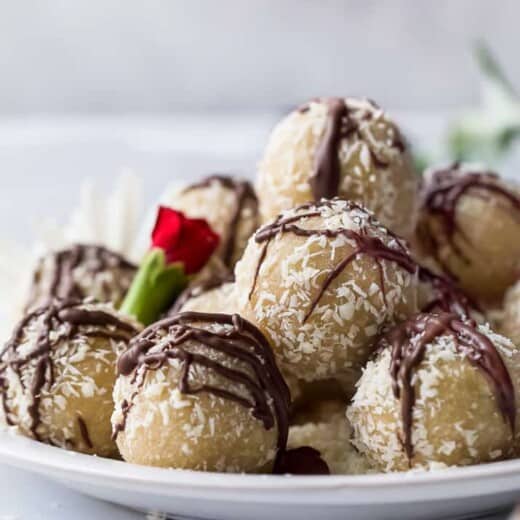 gluten free almond snowball cookies with chocolate drizzle on a plate