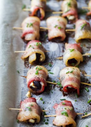 side photo of bacon wrapped figs with herb goat cheese on a baking sheet
