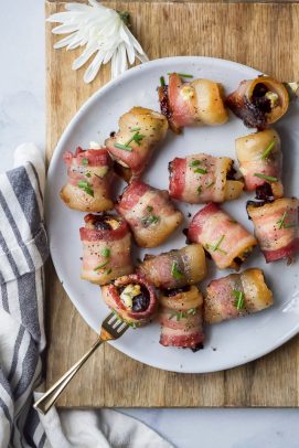overhead photo of bacon wrapped figs with herb goat cheese on a fork and plate