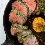 photo of beef tenderloin roast with a fresh herb crust in a cast iron skillet