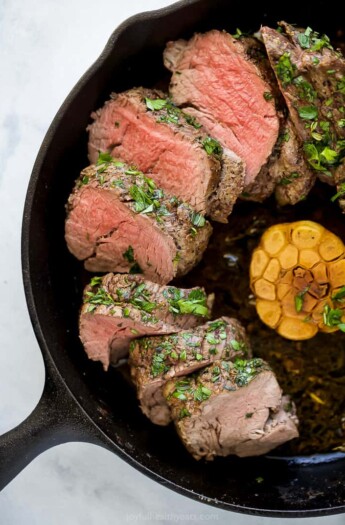 Juicy beef tenderloin with garlic in the skillet.