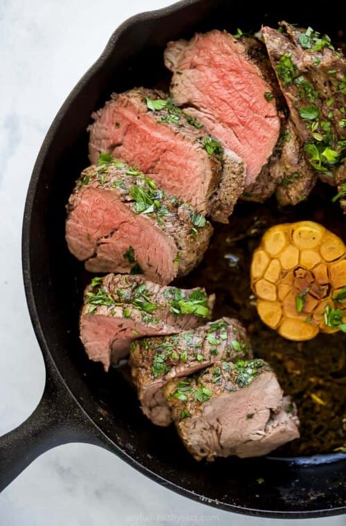 Juicy beef tenderloin with garlic in the skillet.