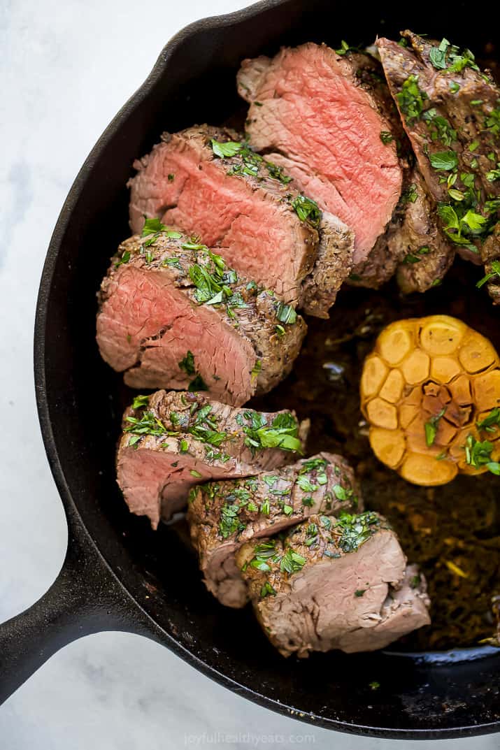 Juicy beef tenderloin with garlic in the skillet.