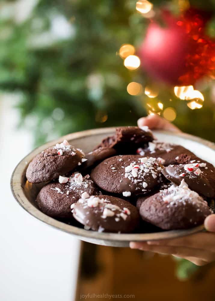 photo of gluten free peppermint chocolate cookies on a serving dish in front of a christmas tree