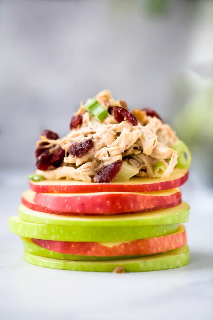chicken salad piled on top of a mound of apple slices