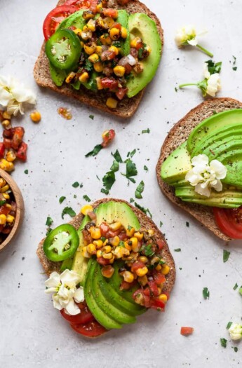 healthy avocado toast topped with charred corn salsa on a board