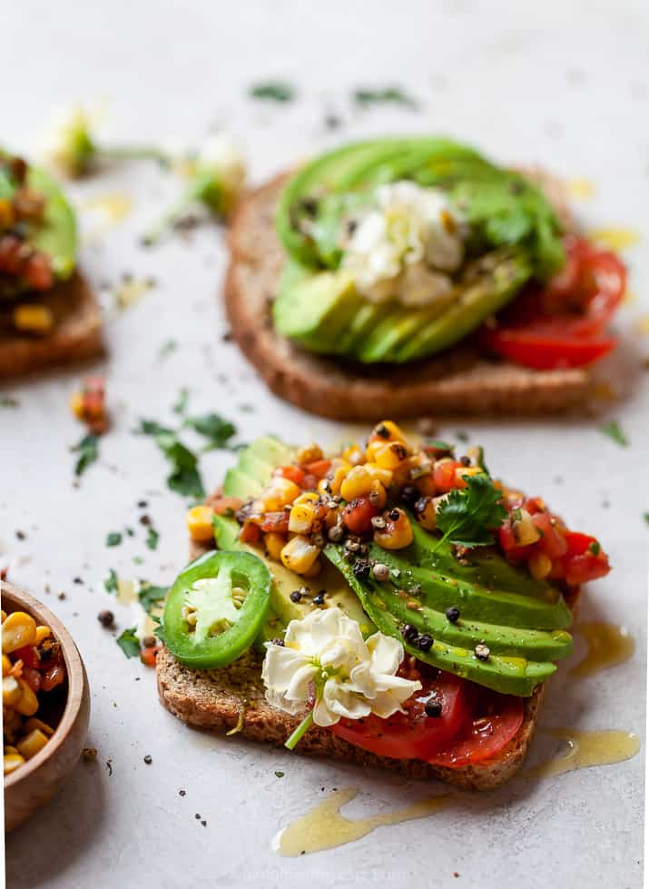 side photo of healthy avocado toast topped with charred corn salsa