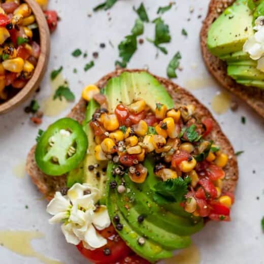 close up of healthy avocado toast topped with charred corn salsa and fresh jalaepno