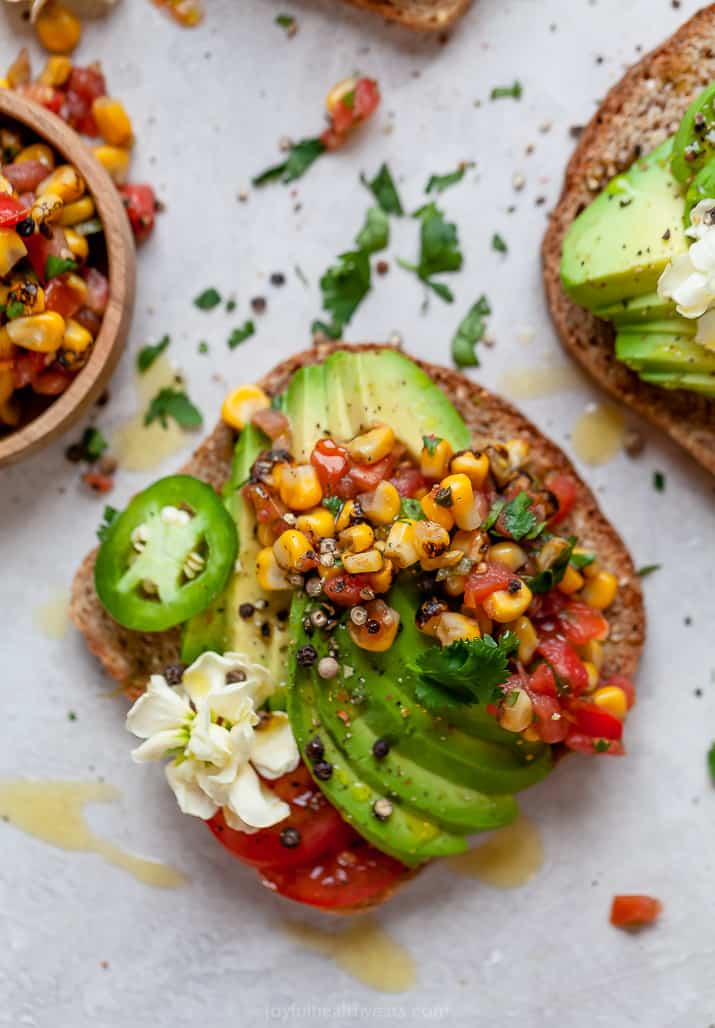 close up of healthy avocado toast topped with charred corn salsa and fresh jalaepno