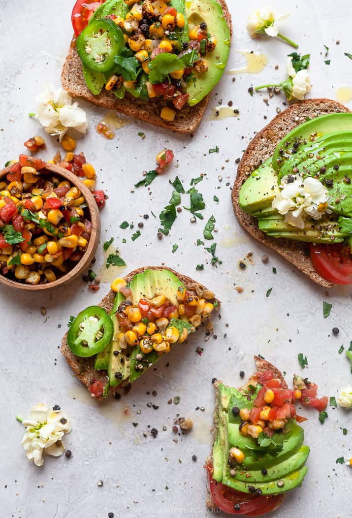 healthy avocado toast sliced in half and topped with charred corn salsa