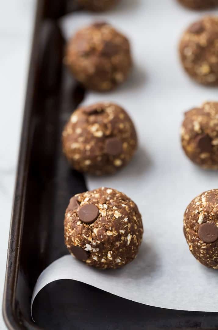 chocolate brownie energy balls lined up on parchment paper