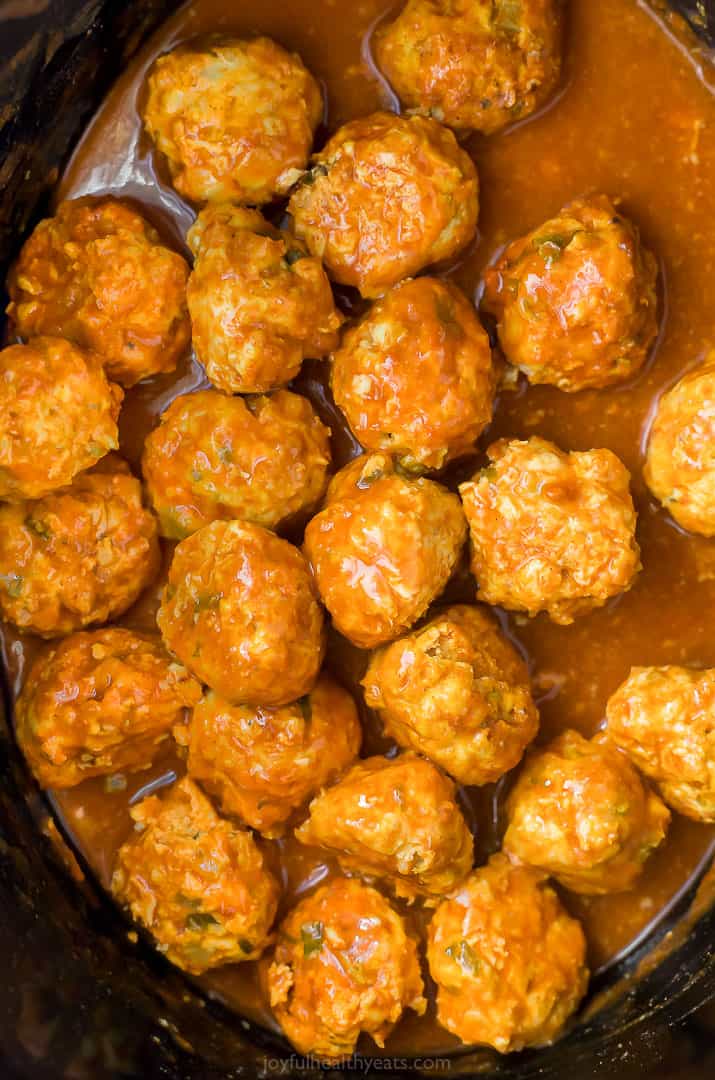 buffalo chicken meatballs covered in buffalo sauce in a crock pot