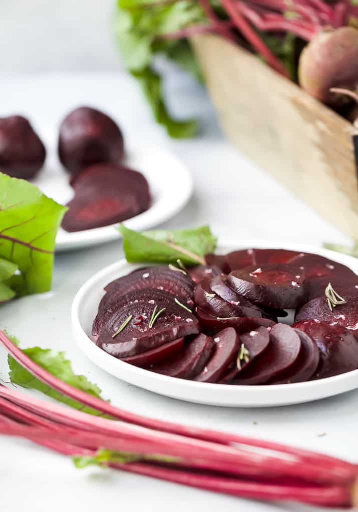 slices beets on a plate that have been cooked in an instant pot topped with rosemary