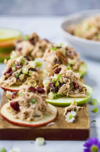 Light and Easy 15 Minute Cranberry Chicken Salad Recipe on an apple sliced served on a cutting board