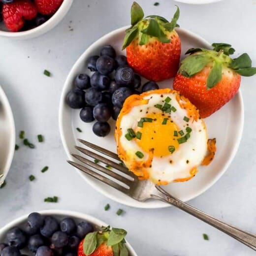 close up photo of sweet potato hash baked egg cups with fresh fruit