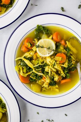 close up photo of healing chicken soup recipe served in bowls topped with lemon