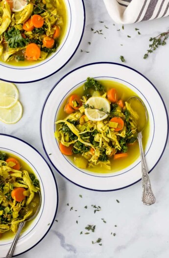 healing chicken soup recipe served in bowls topped with lemon
